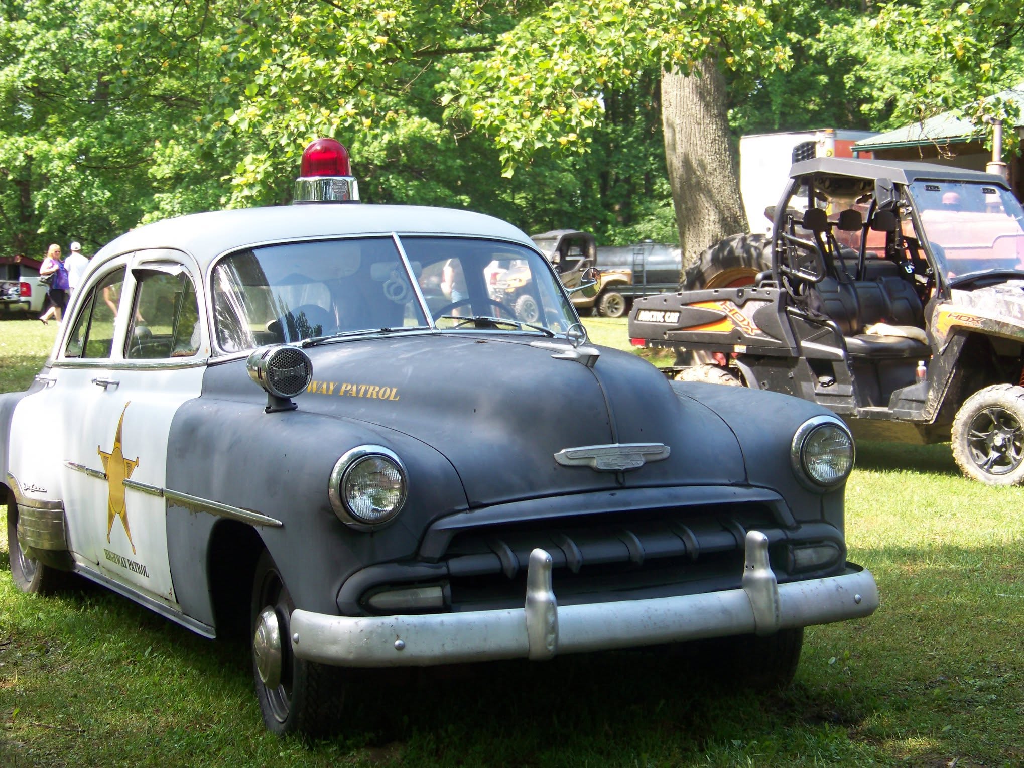 Vintage black-and-white Highway Patrol police car on display on the show grass